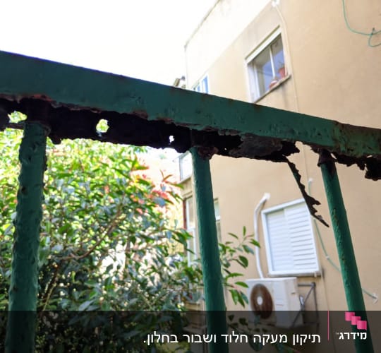 מעקה מתכת חלוד עם חורים ושברים